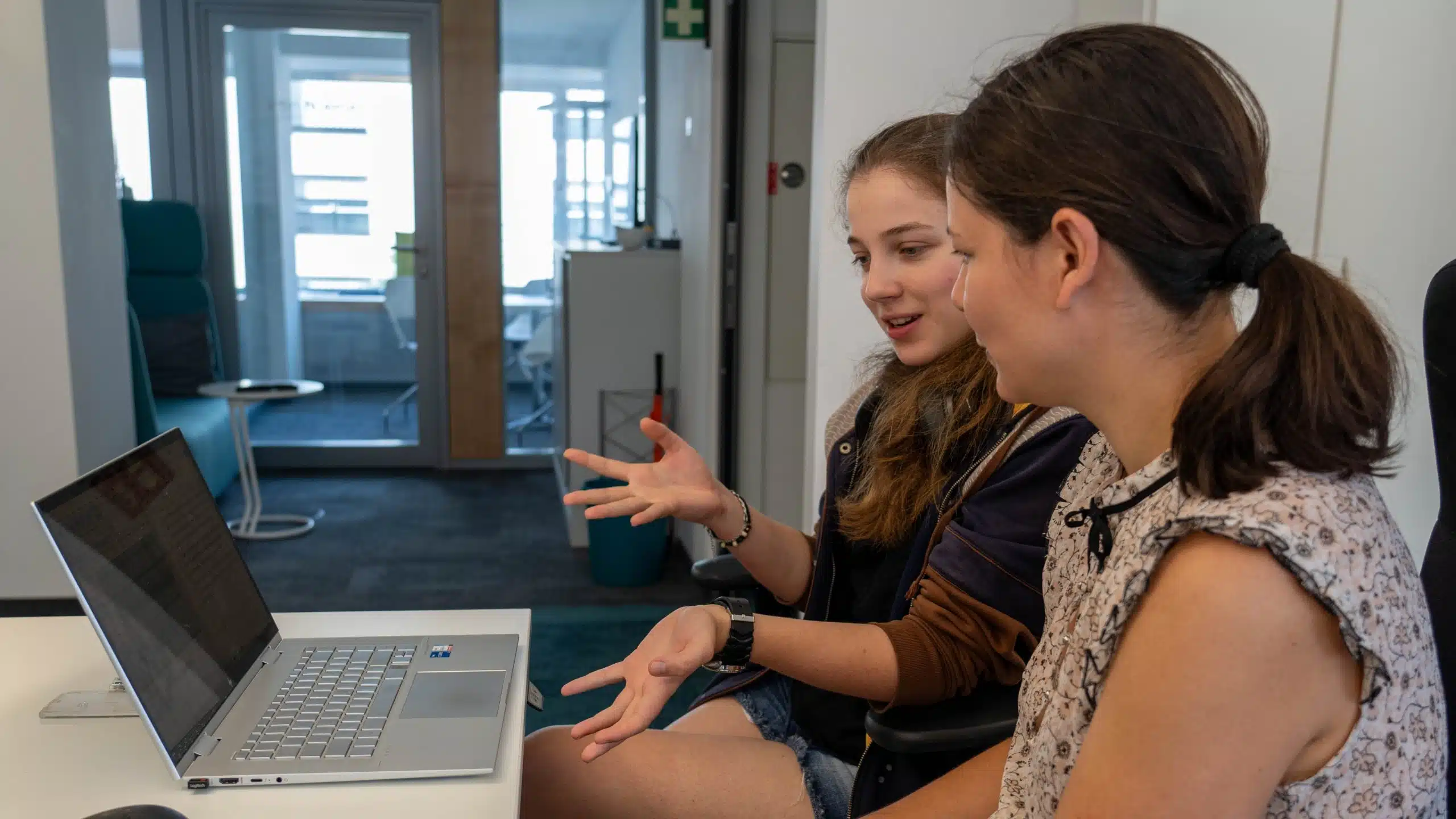 2 Frauen im Gespräch vor einem Laptop