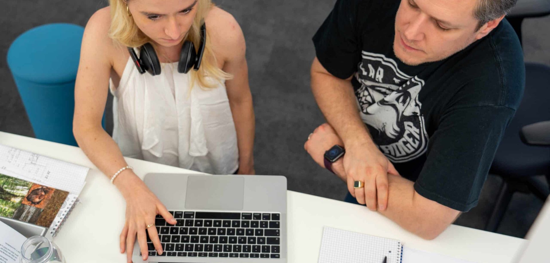 Eine Frau und ein Mann arbeiten gemeinsam an einem Laptop.