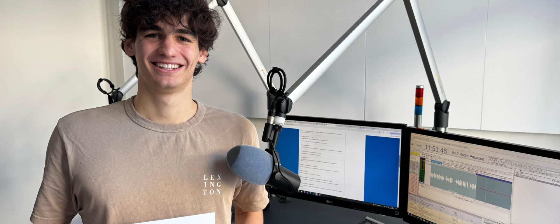 Lars Bergmann im Radiostudio- Er hält seine Hinhörer-Urkunde in der Hand.