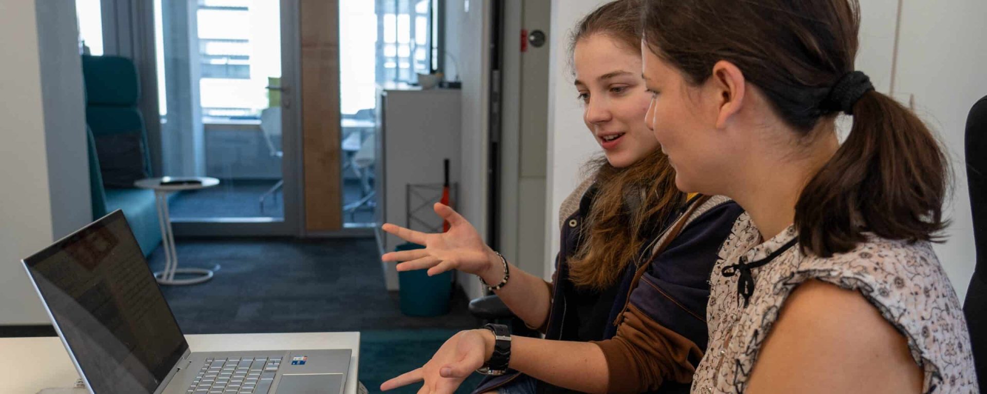 2 Frauen im Gespräch vor einem Laptop