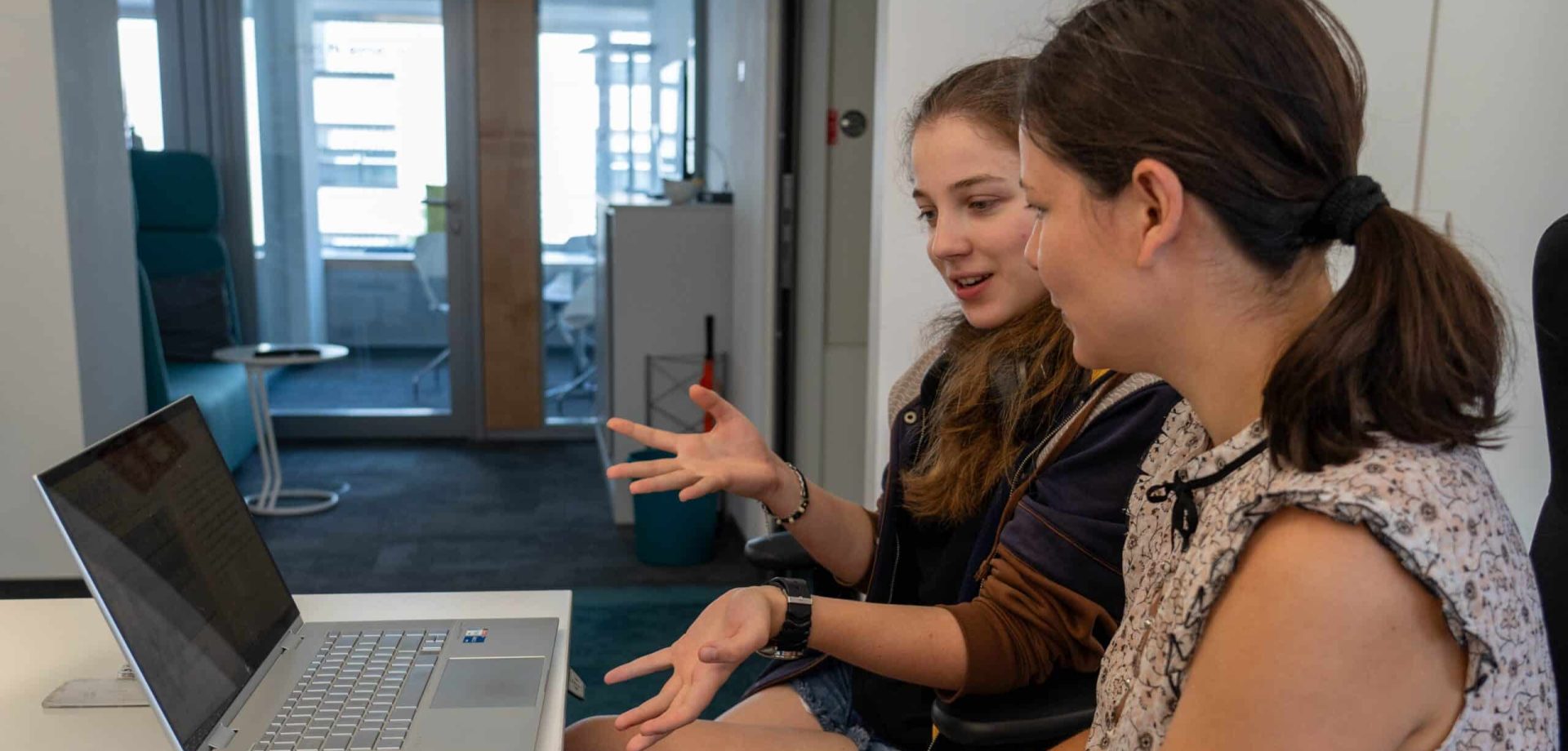 2 Frauen im Gespräch vor einem Laptop