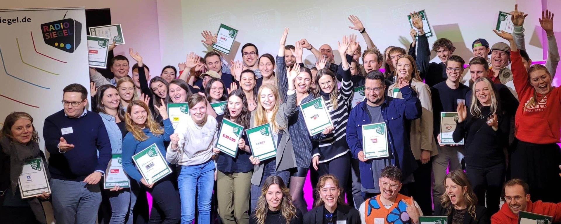 Gewinnerinnen und Gewinner des Radiosiegels 2024 bei der Verleihung auf der Bühne